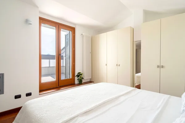 Bedroom with a glazed door opening onto the second balcony and the lake