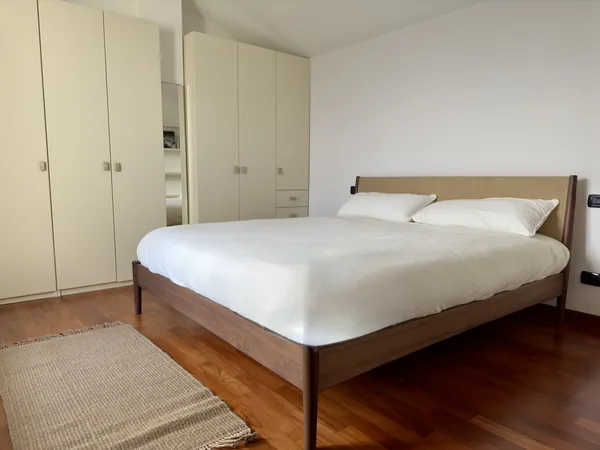 Upstairs bedroom with a king bed, wooden floor and fitted wardrobes