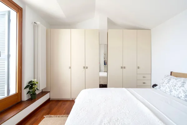 Bedroom with fitted wardrobes and a shuttered window