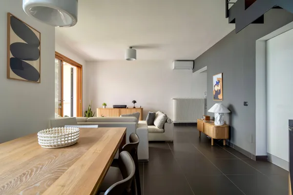 Long wooden dining table looking through to the living area