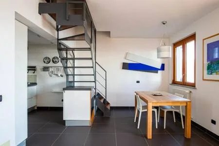 Dining table and chairs beside the open-tread staircase to the upper floor