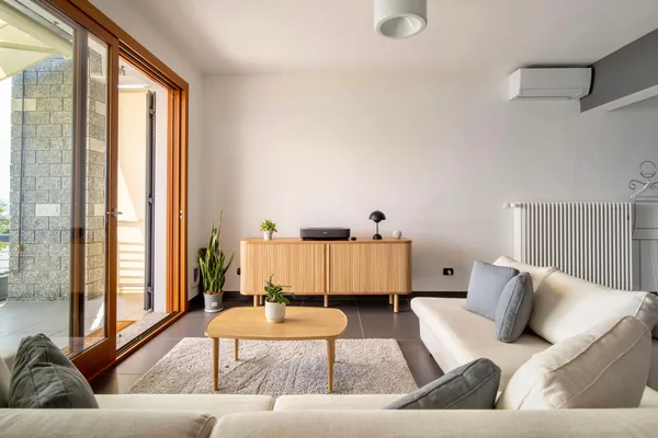 Living room seen from the terrace doors, with the wooden sideboard and coffee table
