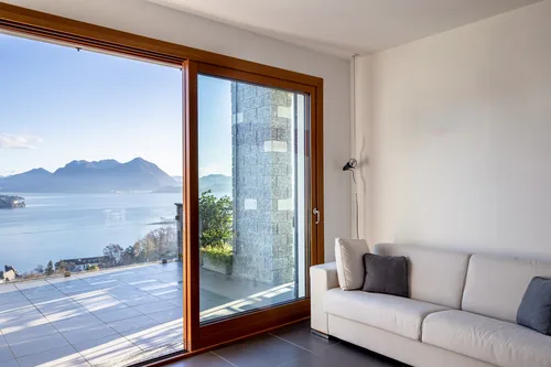 Living room sofa beside sliding doors, with the lake and mountains beyond