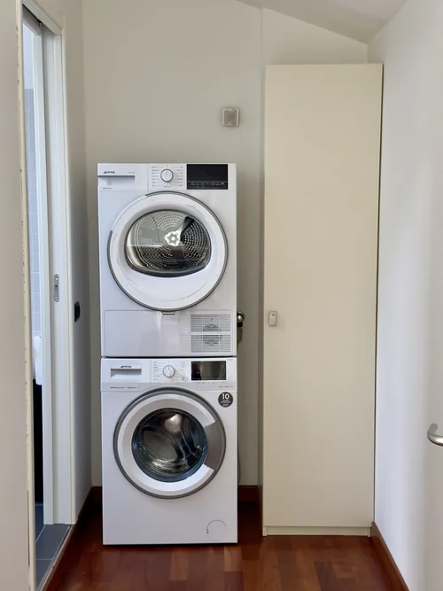 Stacked SMEG washing machine and clothes dryer in a utility recess