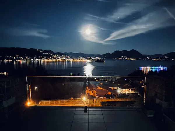 The terrace at night, with a full moon over Lake Maggiore and the town lights below