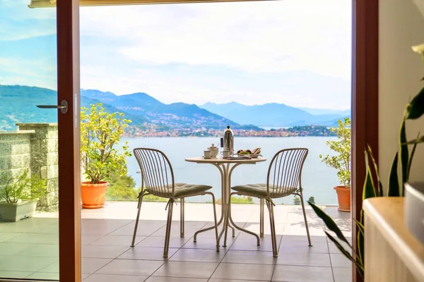 The terrace framed by the open doors, looking out over the lake and mountains