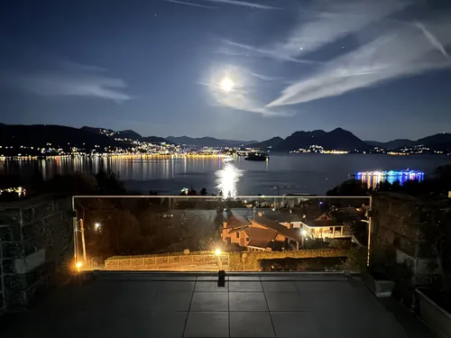 Baveno and Lake Maggiore lit up at night, seen from the apartment terrace under a full moon