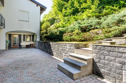 Paved courtyard beside the villa with steps up to the planted slope