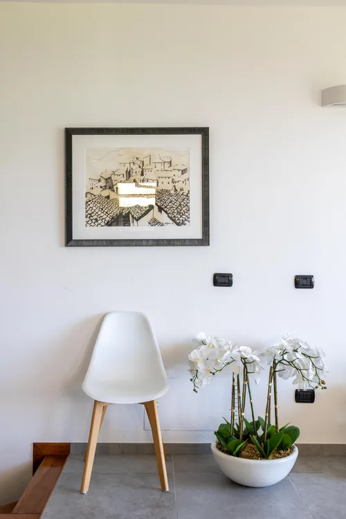 Interior detail: a chair, a bowl of orchids and a framed print