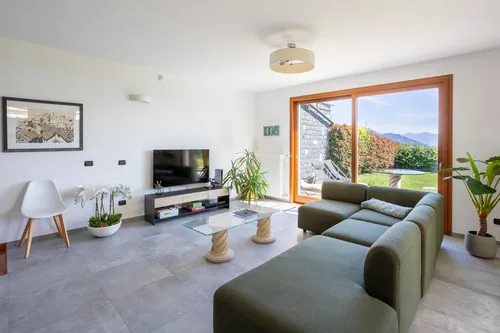 Living room with television, plants and open doors onto the garden