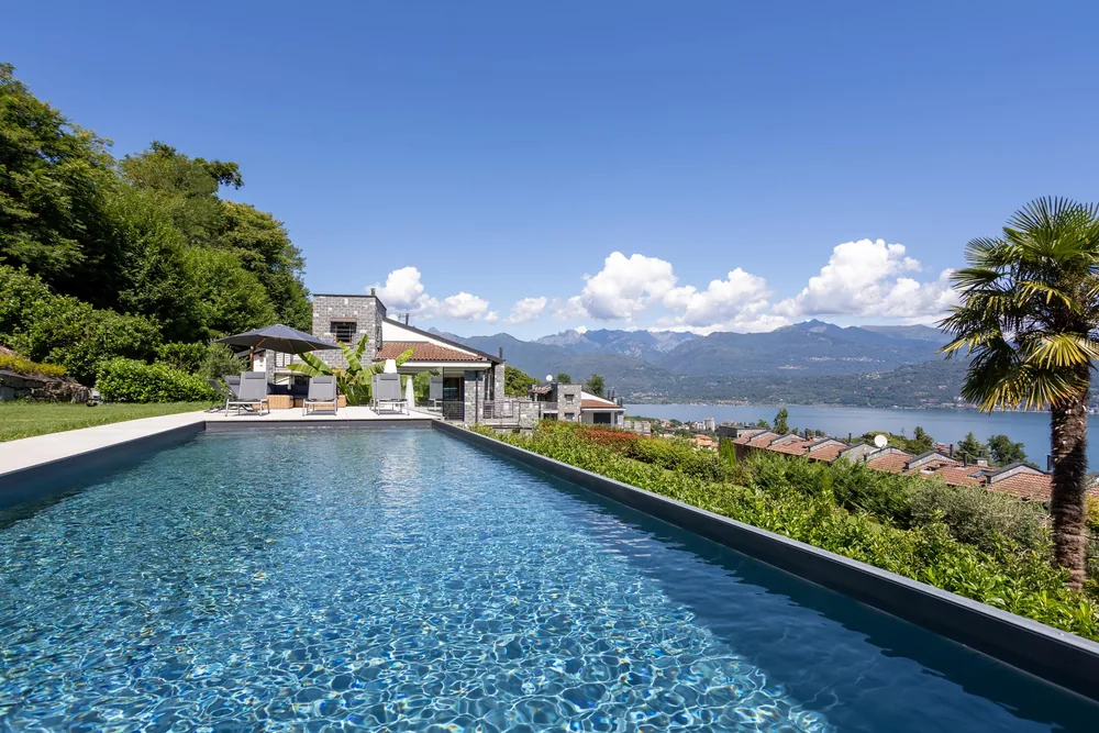 The villa's private lap pool running towards the lake, with the garden either side