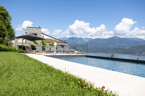Sun loungers along the lawn beside the villa's private pool