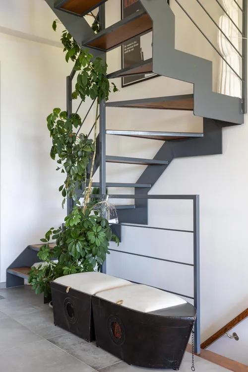 Staircase landing with plants and a bench