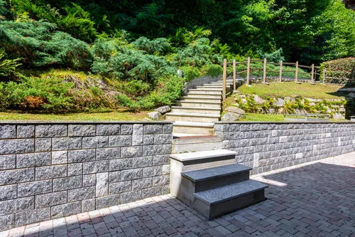 Terraced stone garden walls with steps climbing the slope behind the villa